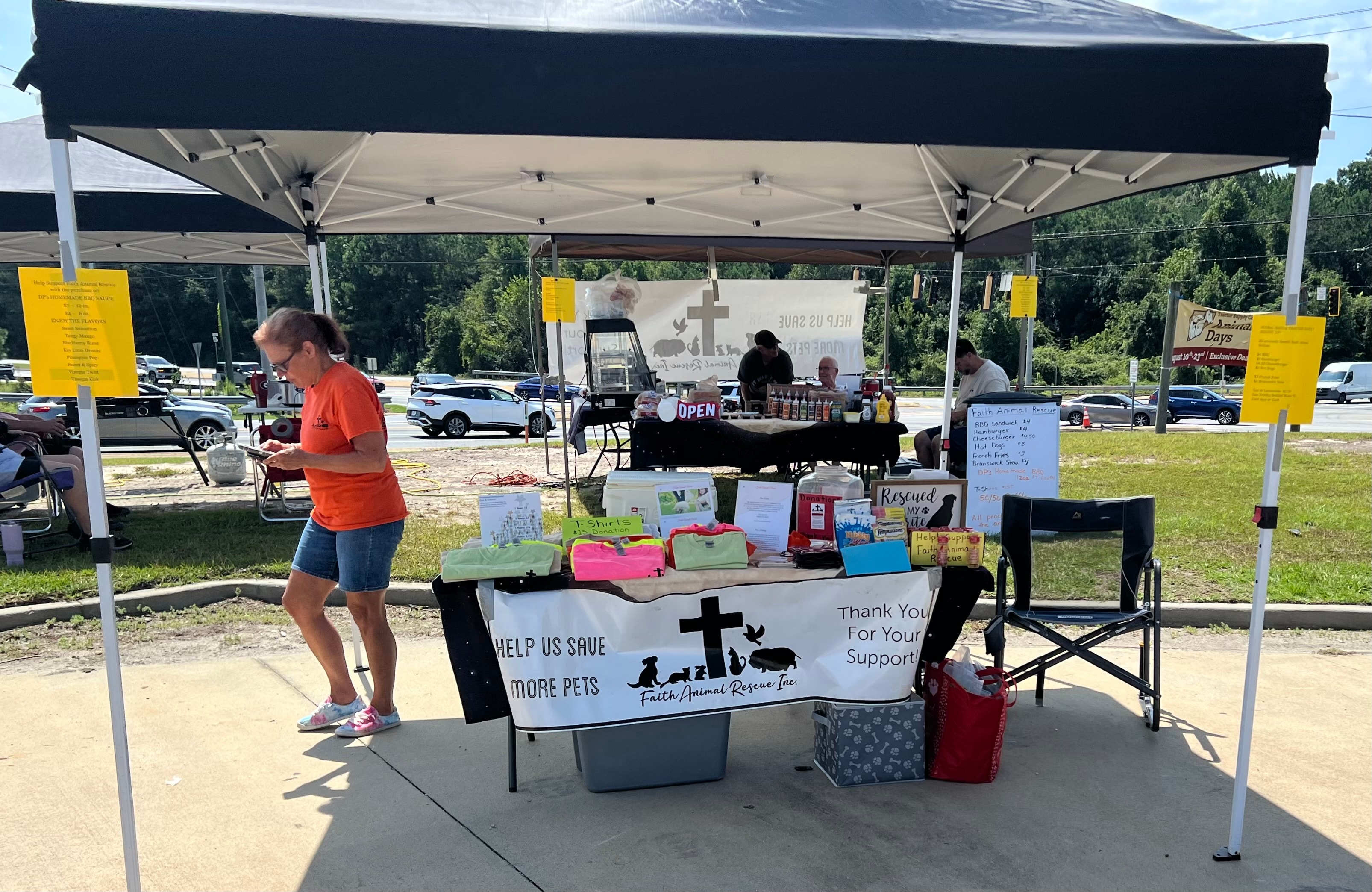 Faith Animal Rescue event booth with t-shirts and donation materials under tent