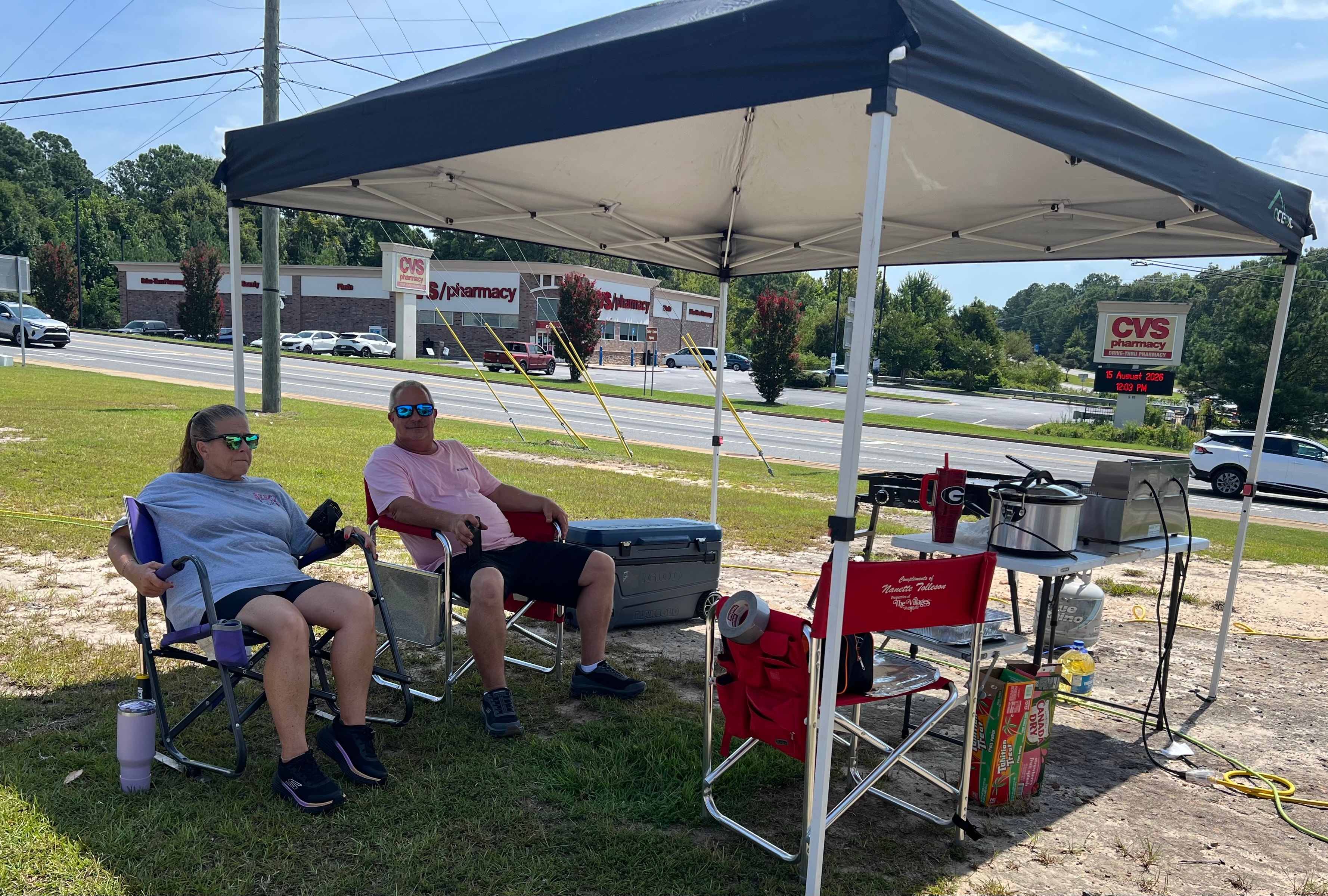 Two Faith Animal Rescue volunteers relaxing under tent at outdoor fundraiser